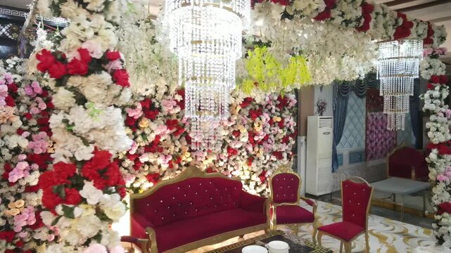 Grand Wedding Stage Decoration with Red and White Floral Wall and Crystal Chandeliers &ndash; South Asian Reception Setup