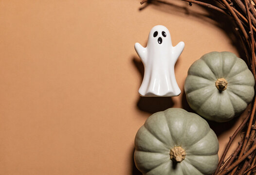 White ghost figurine, halloween decor, green pumpkins, autumn wreath, seasonal harvest, festive arrangement, scary ghost, pumpkin setup, spooky ornament, twig wreath, halloween theme, fall display.