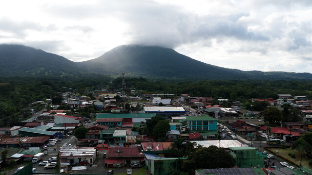 La Fortuna town nestled at the base of Arenal Volcano with lush tropical forest and cloudy sky