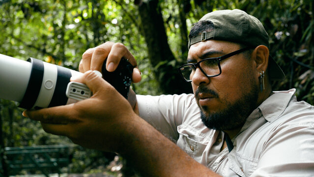 Professional photographer capturing wildlife moments with a telephoto lens in Arenal Volcano National Park, Costa Rica jungle