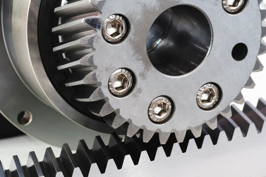 Close-up of meshing metal gears of linear gear drive. metal surfaces demonstrate precision engineering. tech industrial technology background