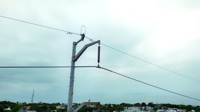 Drone aerial view of electrical transmission pole featuring cable infrastructure and attachment hardware with orbital camera movement