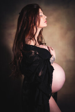 ritratto in studio durante sessione fotografica di maternity di giovane donna in cinta al nono mese