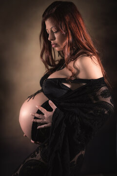 ritratto in studio durante sessione fotografica di maternity di giovane donna in cinta al nono mese