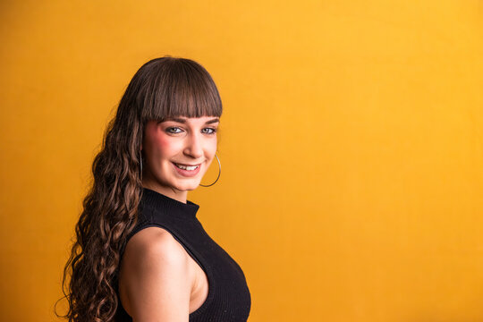 Young woman smiling with confidence on vibrant yellow background