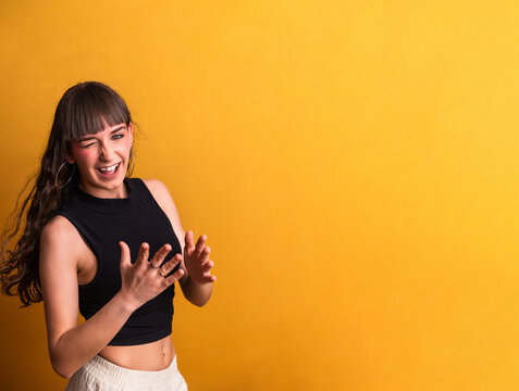 Young woman winking, smiling and performing a dance move