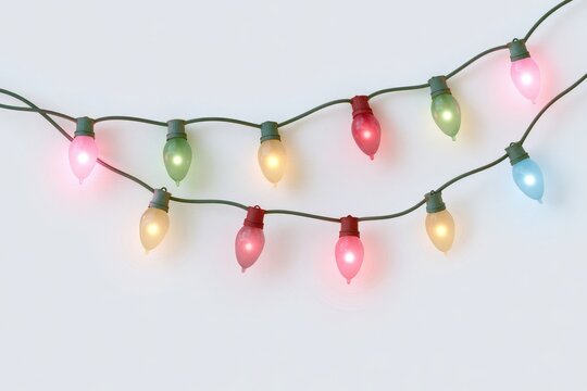 Festive string lights with colorful glowing bulbs isolated on white background