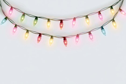 Two curved strings of colorful glowing christmas lights isolated on white background