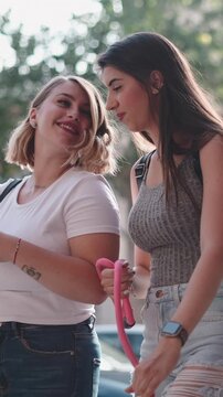 Two women friends walking the city while using a smartphone
