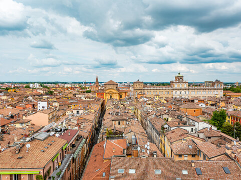 Modena cityscape with its historic buildings, ancient terracotta rooftops, and the Palazzo Ducale under a cloudy sky, showcasing the unique architecture of this Emilia Romagna city