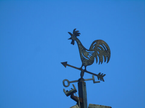 Weather Vane Rooster Silhouette Against Clear Blue Sky