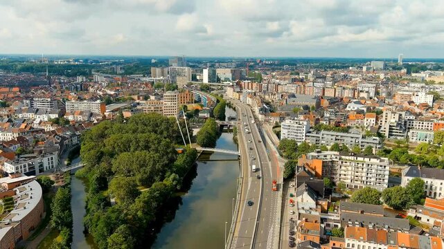 Ghent, Belgium. Esco (Scheldt) river embankment. Panorama of the city from the air. Cloudy weather, summer day. Drone footage, Departure of the camera