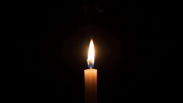 Single Candle Flame Flickering Gently in a Dark Room