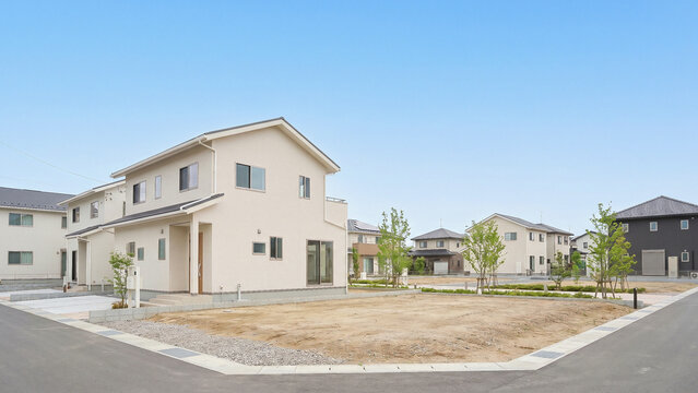 新築の二階建て住宅と整地された更地が並ぶ分譲住宅地の街並み