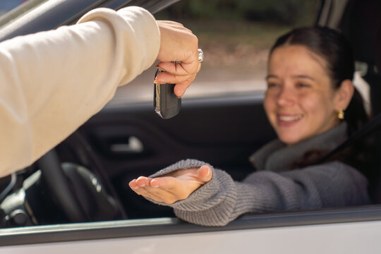 Handing car key to smiling new driver