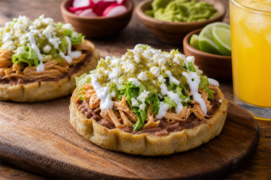 Delicious chicken sopes served on rustic wooden board