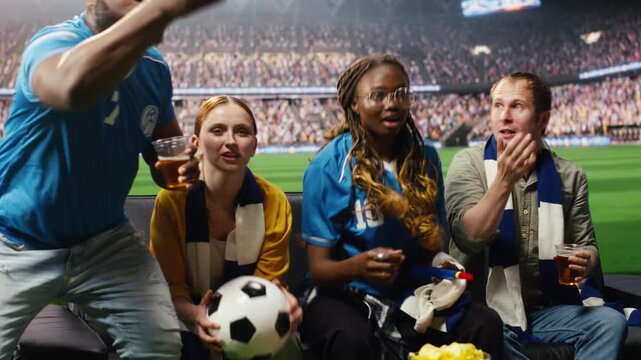 Group of friends follow soccer game at home as immersive broadcast brings them close to the action while supporters drink beer on the couch.