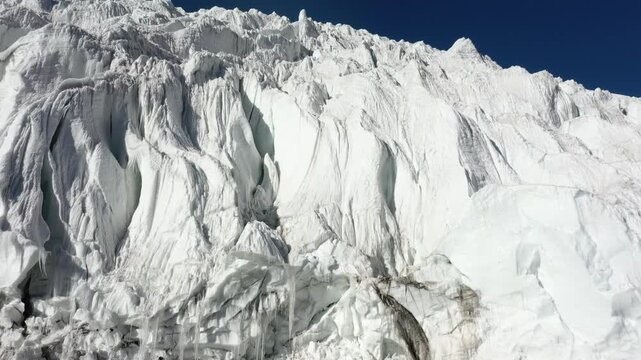 Aerial view of Karola Glacier in Tibet, China, showing majestic snow-capped mountains and ice formations.