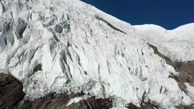 Aerial view of the majestic Karola Glacier in Tibet, China, showcasing snow-capped mountains and pristine ice formations.
