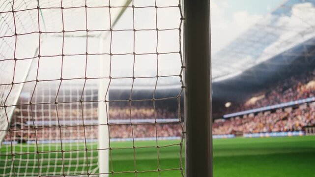 Angled soccer goal net and side post framing empty pitch with blurred crowd stands and bright stadium light, football match on pitch, goal frame and post.