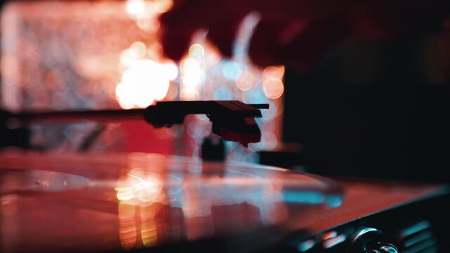 Vinyl record playing on a vintage turntable with glowing bokeh lights. Needle on rotating analog disc audio equipment. Music entertainment device for listener.
