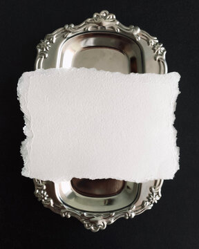 Vintage silver tray with blank torn paper, elegant antique metal platter mockup, white deckle edge card on dark background