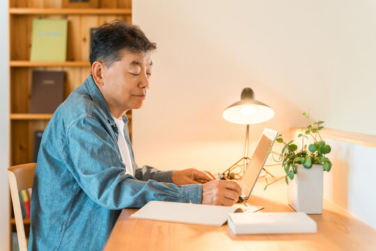 A senior man sitting in his home's study space (study corner, custom-built house)