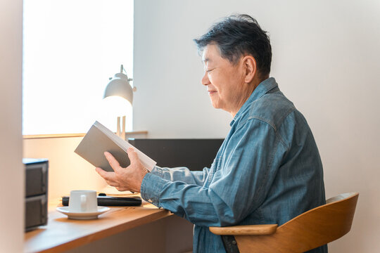 A senior man sitting in his home's study space (study corner, custom-built house)