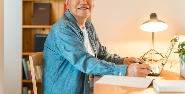 A senior man sitting in his home's study space (study corner, custom-built house)