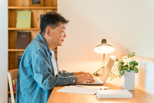 A senior man sitting in his home's study space (study corner, custom-built house)
