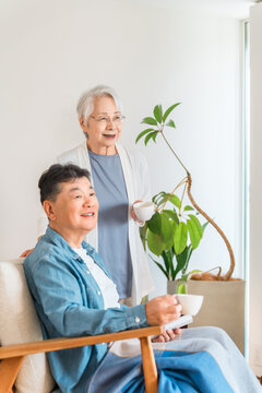 リビングでコーヒーを飲みながらくつろぐシニア夫婦