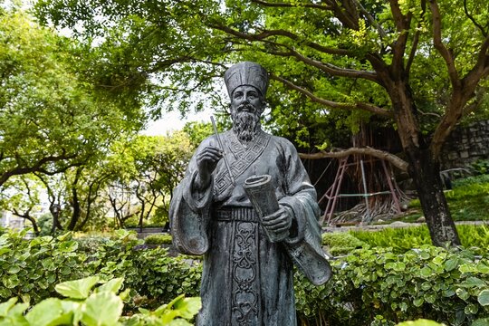 Macau, China April 13, 2026 Bronze statue of Matteo Ricci in traditional chinese clothing holding a scroll in the park