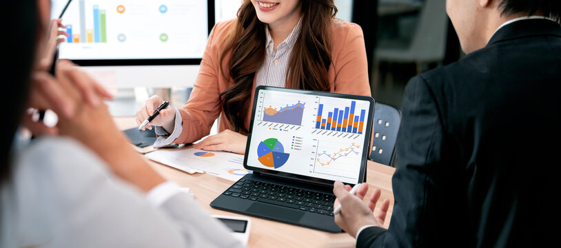 Business people discussing financial data graph on digital tablet during meeting in modern office