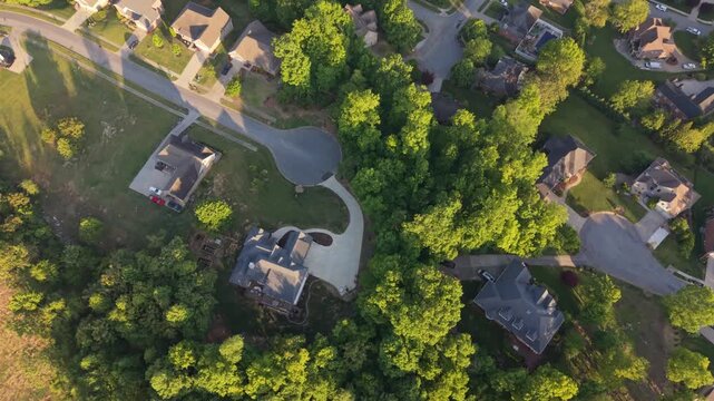 Aerial perspective of a suburban neighborhood in Johnson City, Tennessee, featuring a mix of residential homes, lush greenery, and winding roads, illustrating tranquil environment community layout