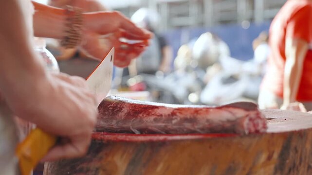 Fish Vendor Slicing Fresh Fish at a Local Market