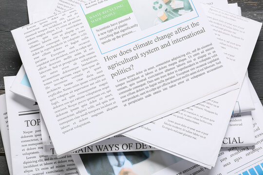Stack of newspapers with climate change and recycling headlines, global politics and environmental news concept, the articles discuss global environmental issues and sustainable practices