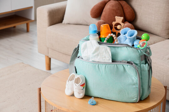 Baby bag with accessories and booties on table in living room