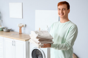 Obraz premium Young man with clean towels at home