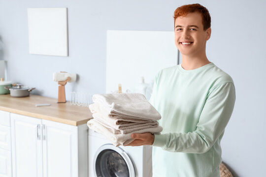 Young man with clean towels at home