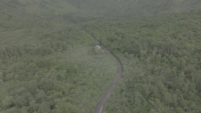 Aerial view of passenger and freight trains traveling along the scenic railway line on Hai Van Pass, Thua Thien Hue province, Vietnam. The drone footage ( d log mode )