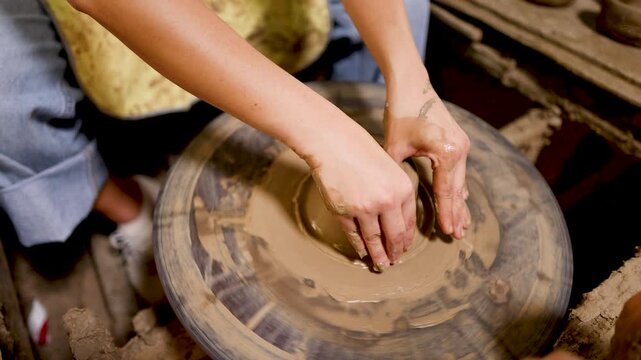 Artisan Hands Shaping Wet Clay on a Rotating Pottery Wheel