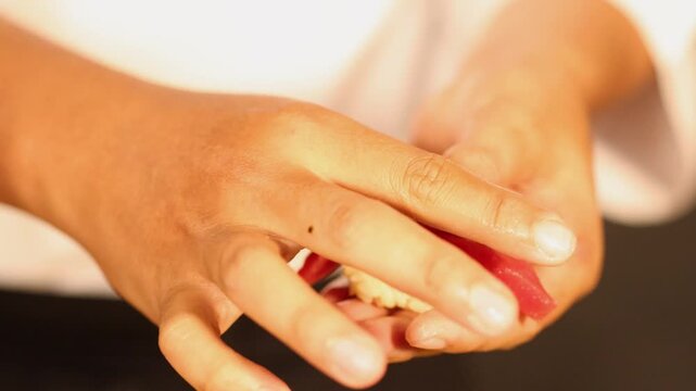 Chef Hands Preparing Fresh Tuna Nigiri Sushi in Japanese Restaurant
