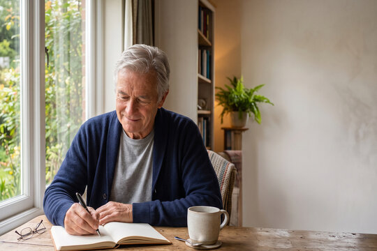 Senior Man Writing Personal Journal for Mental Wellness at Home