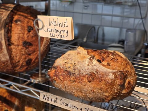 Loaf of bread with seeds.Whole grain churdough bread sits on the shelves in the bakery. The bread has a crisp, golden crust and a beautiful pattern, freshly baked from a variety of grains and seeds.