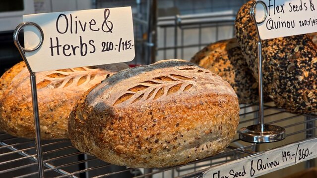 Loaf of bread with seeds.Whole grain churdough bread sits on the shelves in the bakery. The bread has a crisp, golden crust and a beautiful pattern, freshly baked from a variety of grains and seeds.