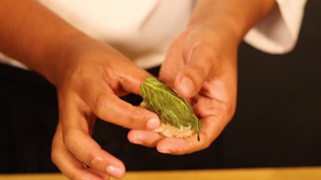 Japanese Chef Preparing Gourmet Sushi with Scallop and Shiso Leaf