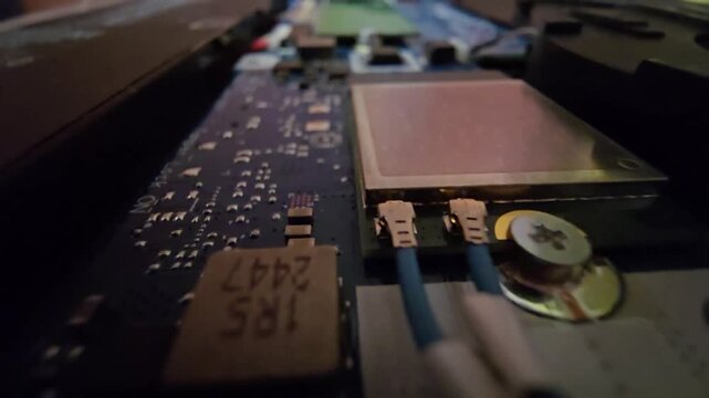Close-up of laptop internals showing a Wi-Fi card with connected antenna cables.