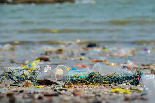 Polluted beach with plastic waste and garbage washed up on the shore, environmental pollution and ocean waste concept, ecological problem on tropical coast	