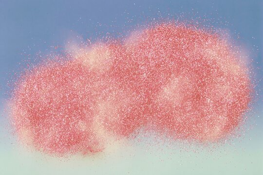 Vibrant coral glitter cloud drifting across a soft blue and green background with a shimmering overexposed aesthetic for a dreamy abstract celebration