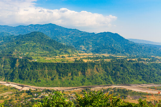 View of India Bhutan border, Bhutan mountains of Himalayas , green forests and Jaldhaka river flowing between Bhutan and India, view from Dolgaon view point at Jhalong , Dooars - West Bengal , India.